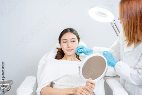 Cuadro en lienzo Asian woman consulting with a doctor at a modern aesthetic clinic for facial treatment
