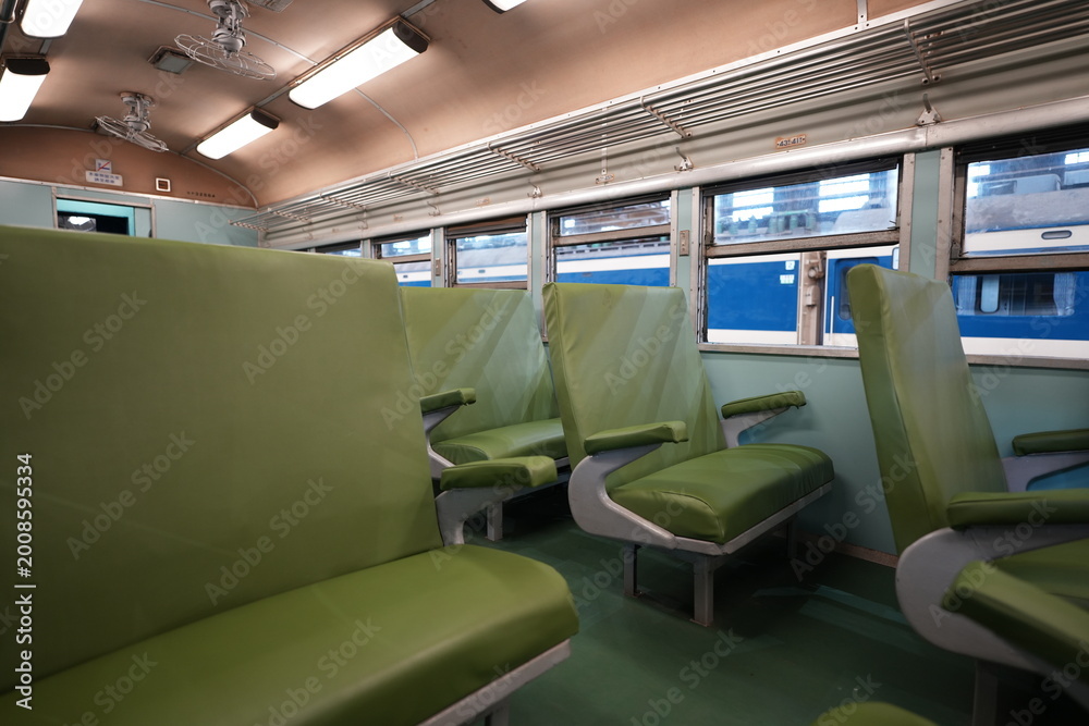 Fototapeta premium Interior of a vintage train carriage with green seats.