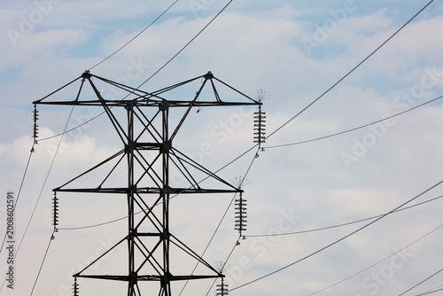 Cuadro en lienzo High voltage power transmission tower with electrical cables against a cloudy sk