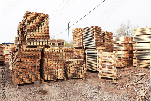 Lumber warehouse. An open-air wood processing workshop. Woodworking. Manufacture of pallets made of wood for cargo transportation. Natural wood