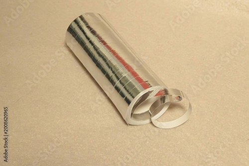 A metal cylinder garland lies flat on a light surface