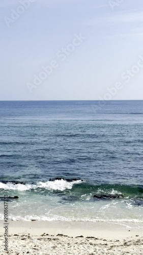 Calm Blue Ocean Waves Crashing on a Sunny Sandy Tropical Beach
