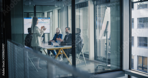 Photos Business Team Meets in a Glass Conference Room to Review Digital Dashboards, Sha