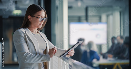 Konstfotografi Businesswoman Uses a Digital Tablet in a Bright Office Hallway to Check Project