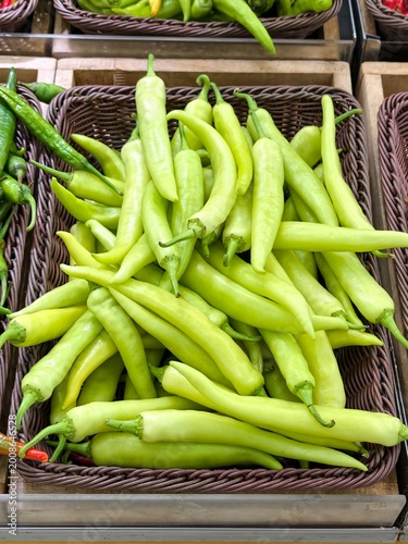 Fresh Green Chili Peppers in Wicker Basket at Market Stall