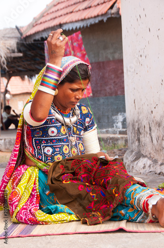 Tribal women sewing ethnic and traditional hand embroidered dresses, india