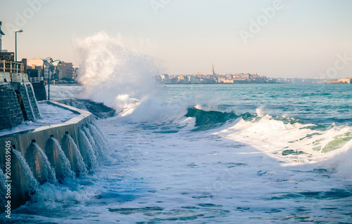 Tableau sur toile A wave breaks during the high tide at Rochebonne beach in Saint-Malo - France