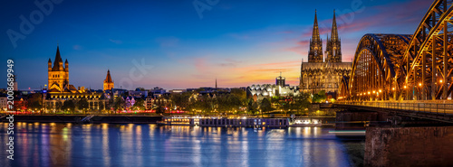 The illuminated skyline of Cologne, Germany, stretching from the old town along river Rhine to the Cathedrale during dusk