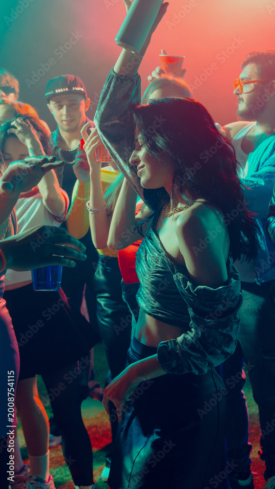 Fototapeta premium A vibrant nightclub scene with people dancing and enjoying music under colorful lights. Concept of nightlife party, youth, summer, festivity, celebration