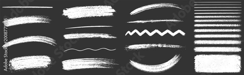 Photos Collection of various white paint brush strokes, dry brush textures, lines, and shapes isolated on a dark background for design elements and overlays