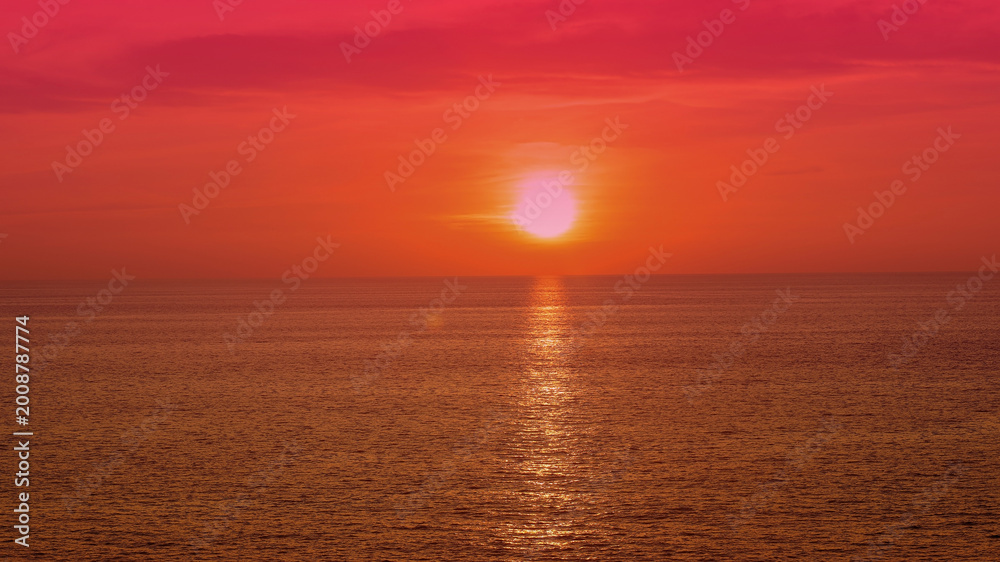 Fototapeta premium A breathtaking sunset colors background or sunrise illuminates the ocean horizon and serene seascape