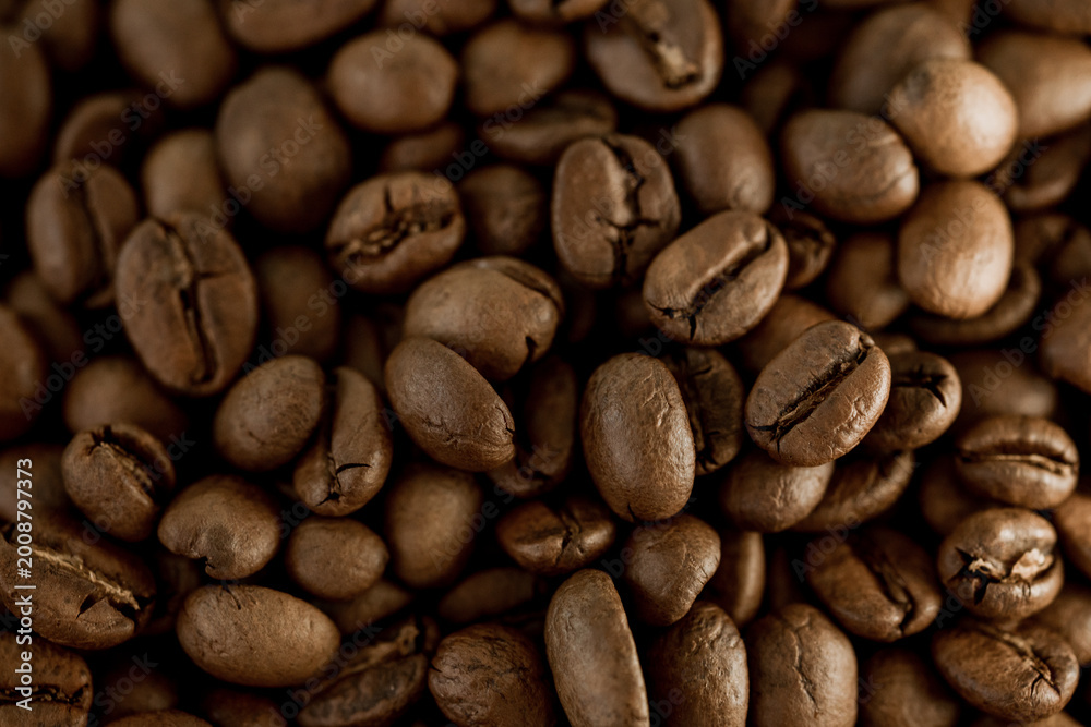 Obraz premium Close-up of roasted coffee beans on white background, rich aroma and texture, perfect for espresso concept, café menu, and energetic morning beverage theme. 