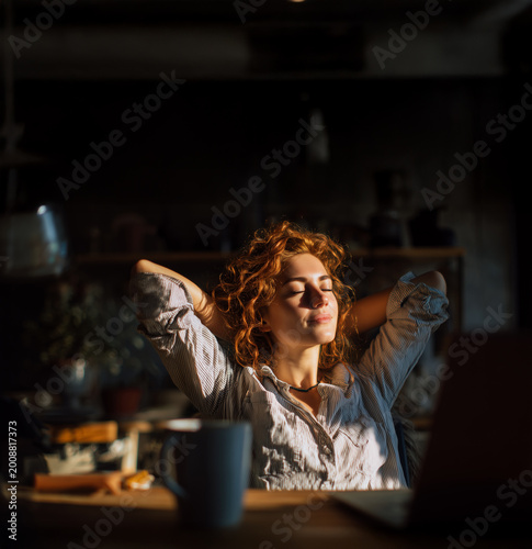 Calm freelancer relaxing after work in cozy home office with coffee