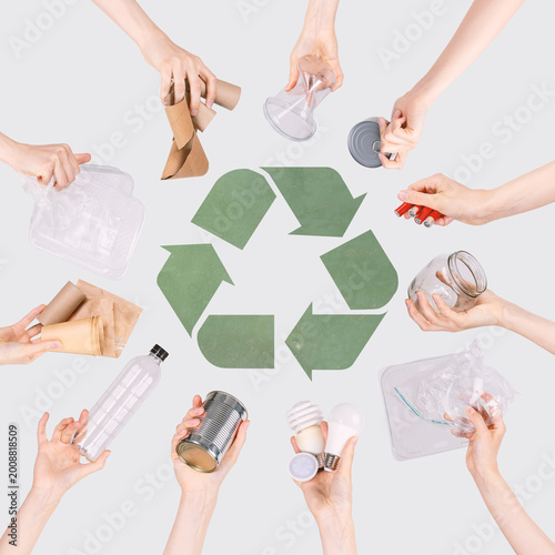 Hands holding various waste materials for recycling and waste management