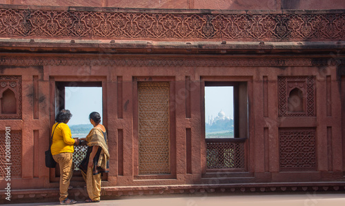 Romantic Indian couple seeing Taj Mahal from red fort, Agra, India.