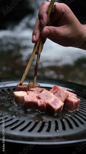 Close up slow motion of beef cubes cooking on grill with visible smoke and heat. Texture and sizzling effect enhance appetite appeal, perfect for food marketing, barbecue concept, and culinary visuals