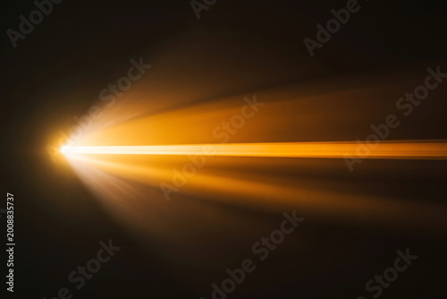 golden light trail abstract motion blur on dark background