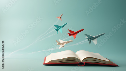 Tiny airport on a book with paper airplanes as real jets