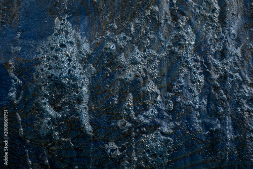 Fotografie Macro full-frame shot of frothy blue natural indigo dye residue clinging to a freshly dipped batik fabric surface, creating a rich organic texture