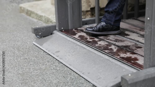 Close-up of Male Legs in Black Leather Shoes Stepping on a Padded Entry Ramp