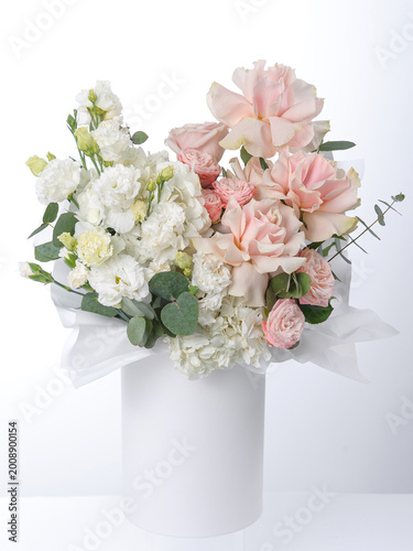 Obraz na plátně An exquisite floral arrangement in a delicate flesh-colored hatbox with roses and eustoma