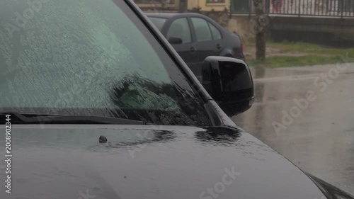 Dark Car Parked Under Heavy Rain and Gray Skies