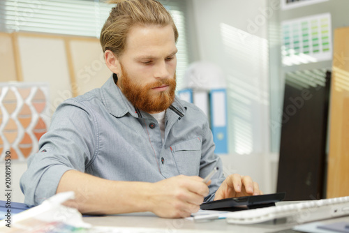 Foto man using calculator and writing on a notepad