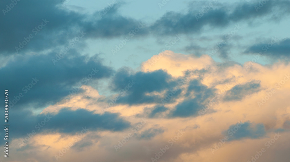 Obraz premium Sunset sky background, colorful fluffy clouds lit by sunshine in the vast evening sky