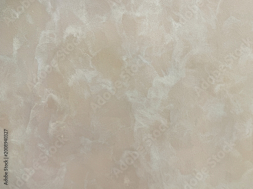 Light beige textured paint washed on a wall or panel, in random lime washed pattern. Seamless background texture.