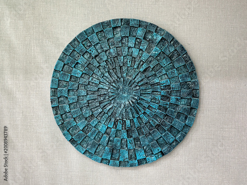 Object of round artwork of rustic mosaic tiles in blue green teal color arranged in radial sunburst pattern. Antique interior decoration or accessories, on a white background.