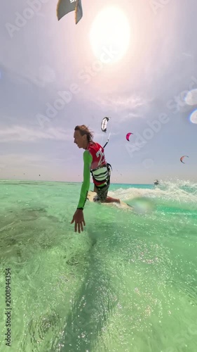 skilled kitesurfer jumping changing stance landing smoothly riding fast on turquoise sea under clear summer sky enjoying freedom adrenaline extreme sport lifestyle adventure travel energy outdoors