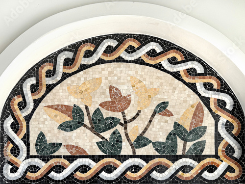 Close up of white based mosaic art tiles forming a tree with leaves and branches pattern. In orange, yellow, and brown color. Exotic resort Mediterranean vibe. Seamless background texture.