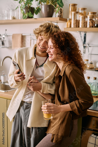 Canvas Print Curly couple sharing joy and laughter in a stylish modern apartment together