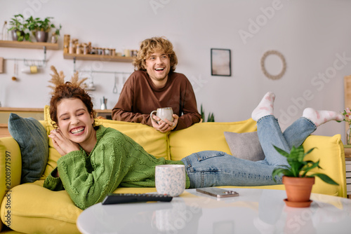 Curly young couple enjoying a cozy moment in their modern apartment