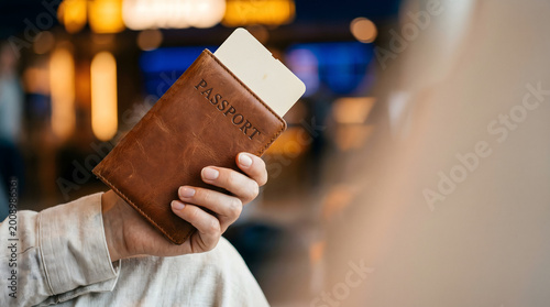 Quadro su tela traveler holding passport and boarding pass at airport check-in counter