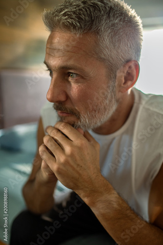 Fotografie Mature man deep in thought at home