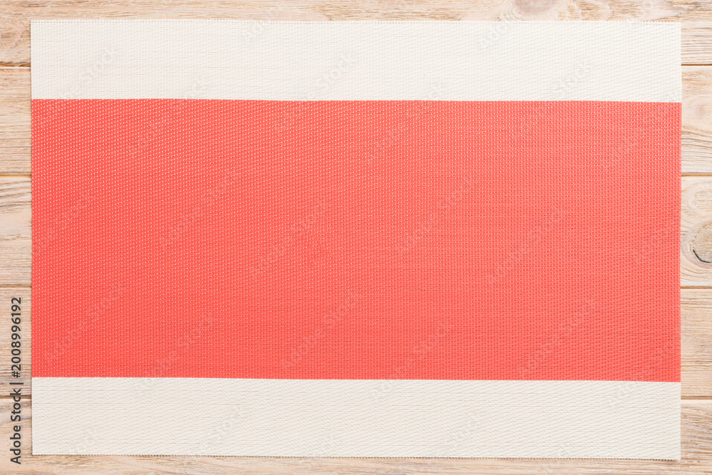 Fototapeta premium Top view of red tablecloth for food on wooden background. Empty space for your design