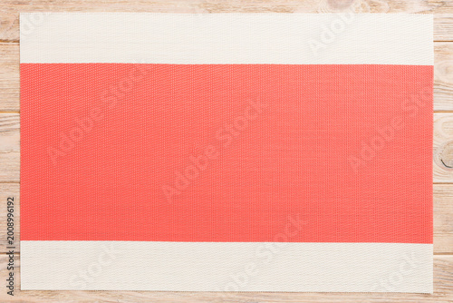 Top view of red tablecloth for food on wooden background. Empty space for your design