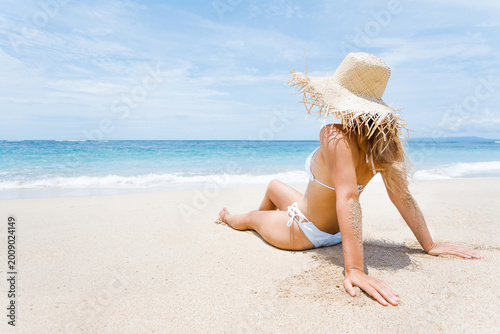Woman lies on the white sand on the beach
