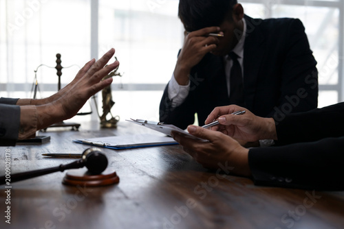 Φωτογραφία Lawyers discussing and signing legal contract with stressed client in office