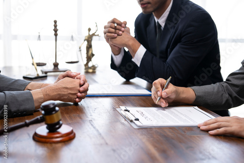 Lawyers and client reviewing contract before signing legal document in office