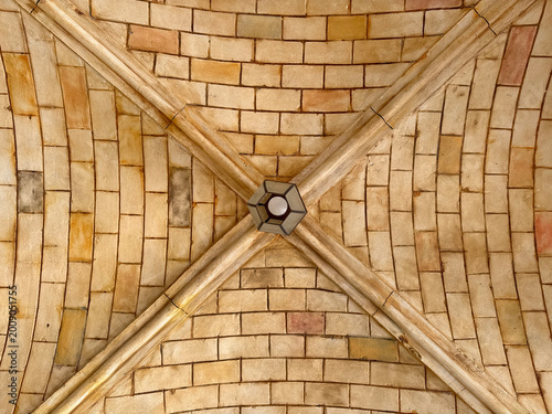 Replica of medieval Roman underground vault architecture with curved and ribbed vault ceiling made of stone bricks. Roman pillars with intricate details or carved capitals. Medieval atmosphere