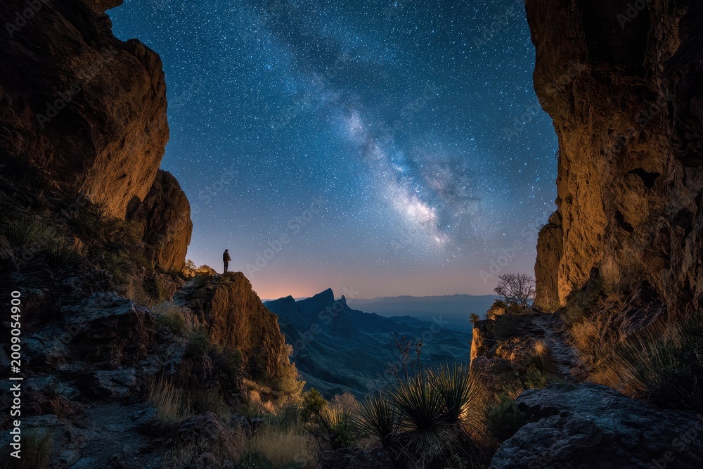 Fototapeta premium Starry night over Chisos Basin: Emory Peak silhouette beside Window Trail in a Texas desert landscape
