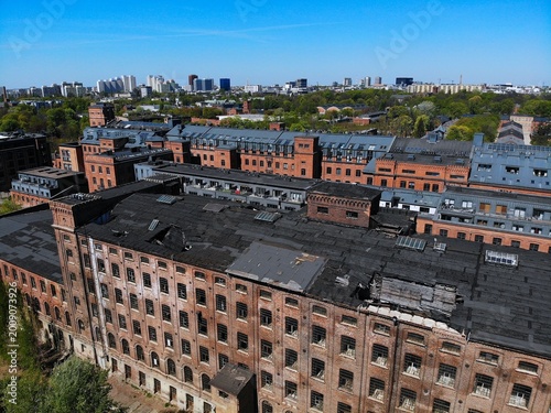 Lodz city in Poland. Lodz industrial heritage with renovated historic Scheibler textile factory in background and deteriorated abandoned second factory in foreground.