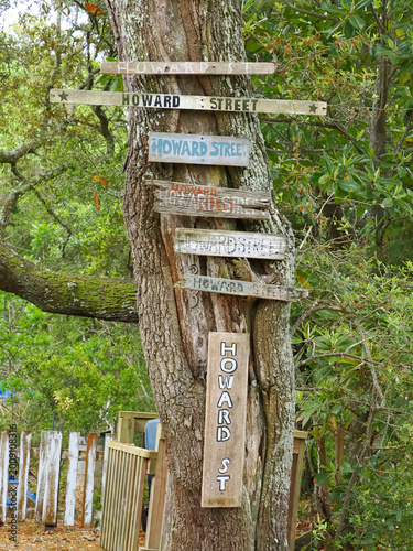 Foto Old weather used vintage signs pointing in different directions on Howard Street, Ocracoke Island, NC