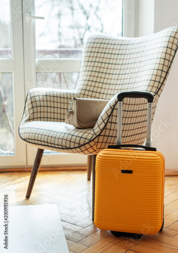 Yellow suitcase and handbag preparing for travel journey