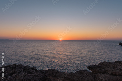 The peaceful sea at dawn or dusk, with serene and calm waters.