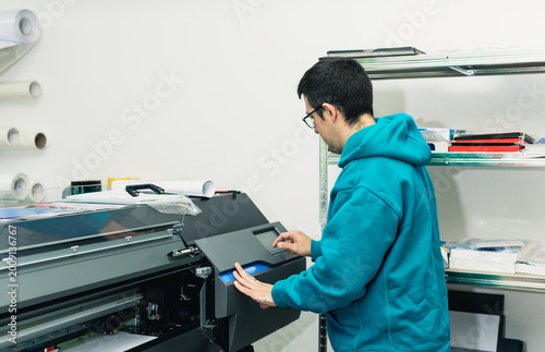 Worker printing on large format digital industrial printer