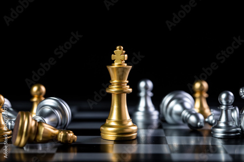 Foto Golden chess king on board with fallen pieces, leadership and victory concept