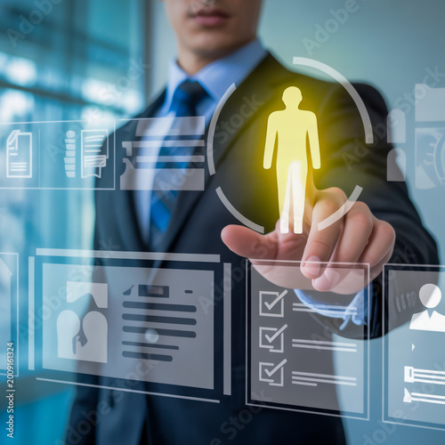 A professional business photo of a person in a dark suit and blue tie interacting with a holographic user interface.